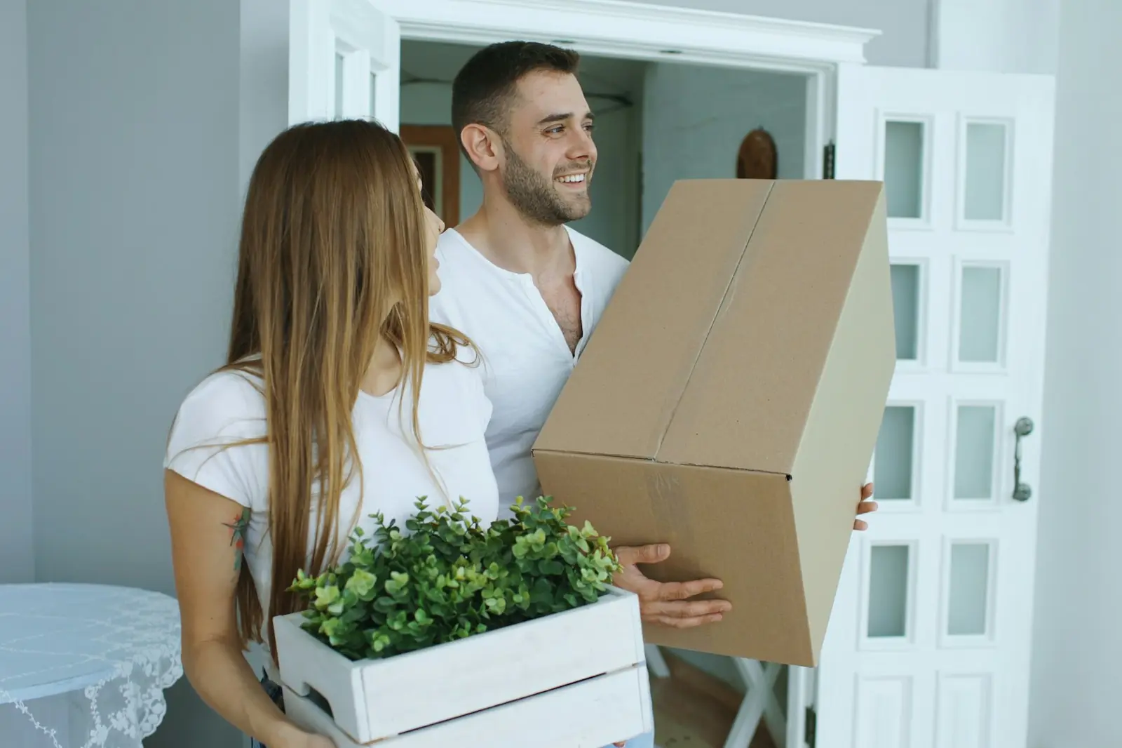 Renters carrying moving boxes into a new apartment